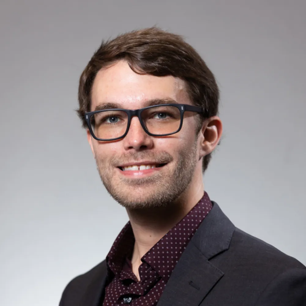 A professional headshot of Austin Broussard.