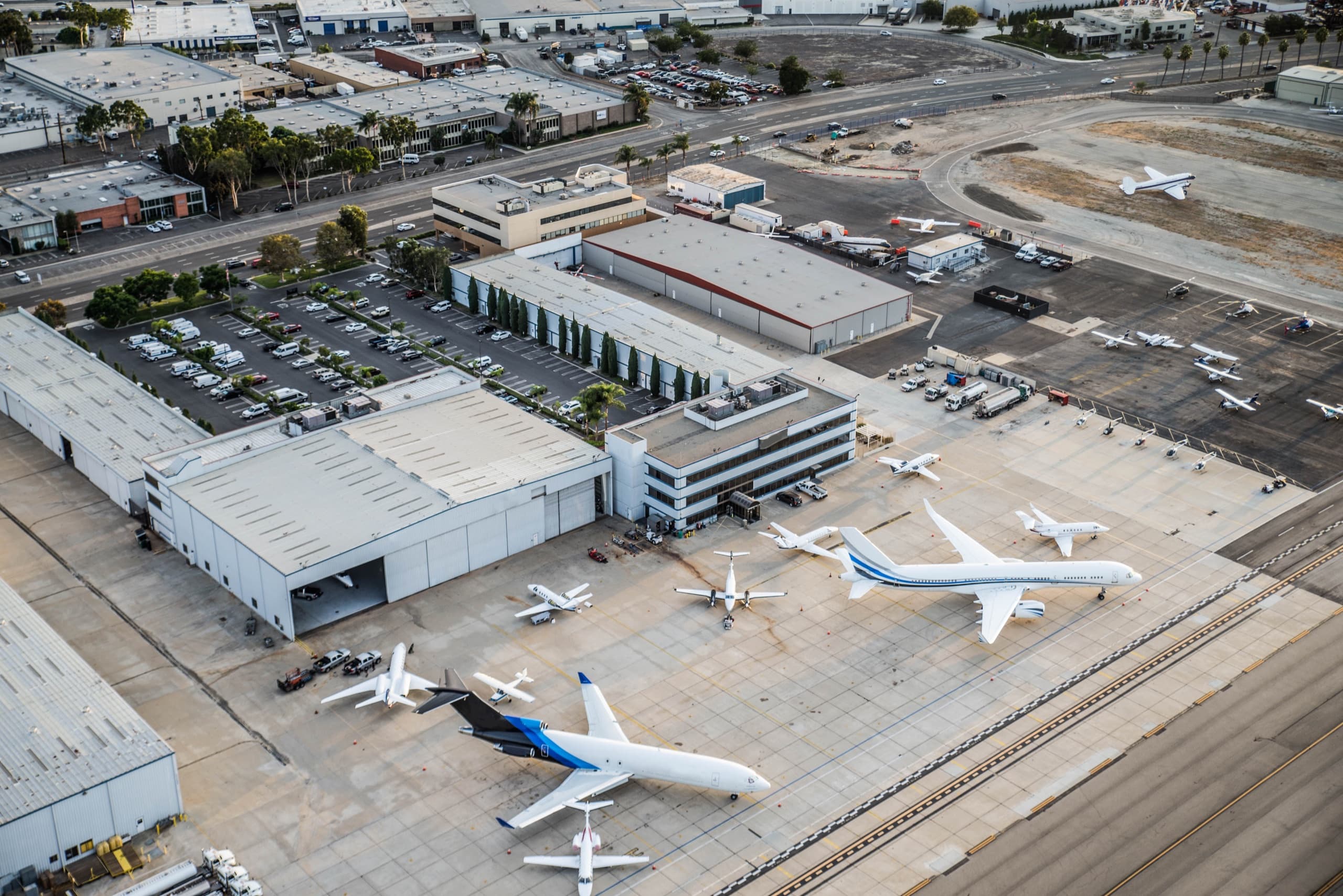 Airport parking facility with vehicles and travelers.