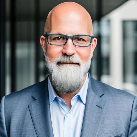 A professional headshot of Joseph Ernest.